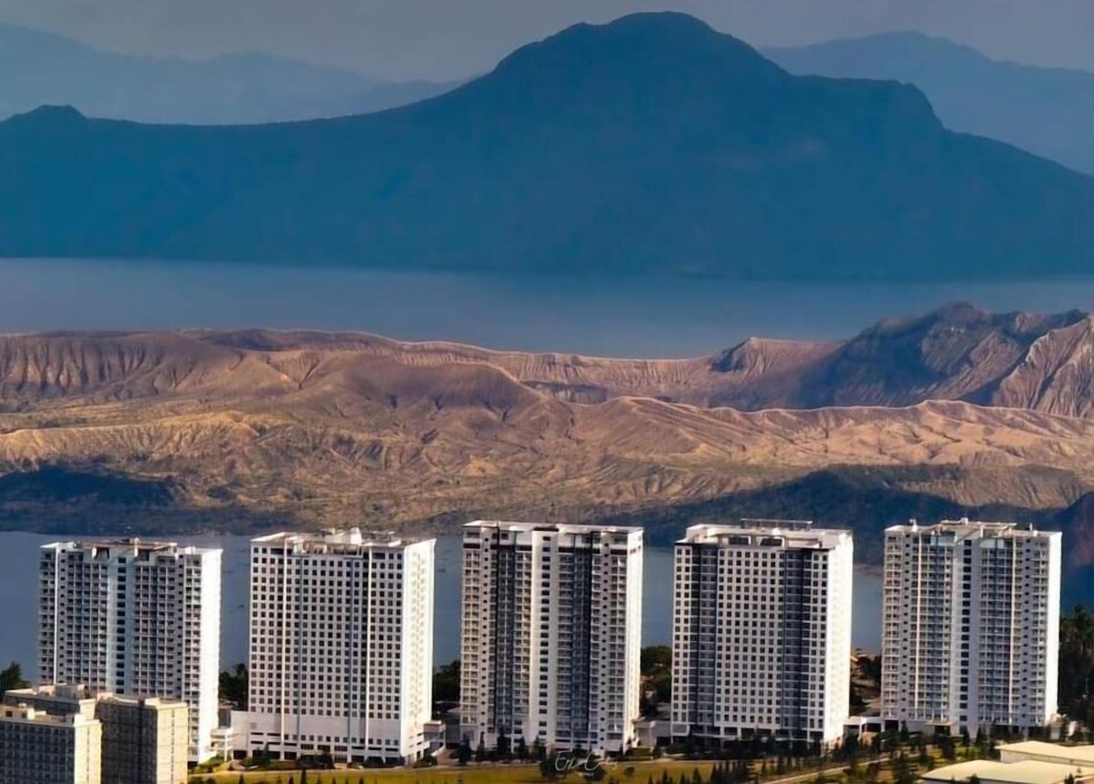 A row of high-rise buildings with a mountainous backdrop.