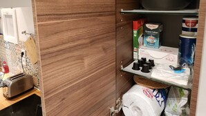 Une cuisine équipée d’un meuble en bois intégré, d’un grille-pain et de divers appareils de cuisine.