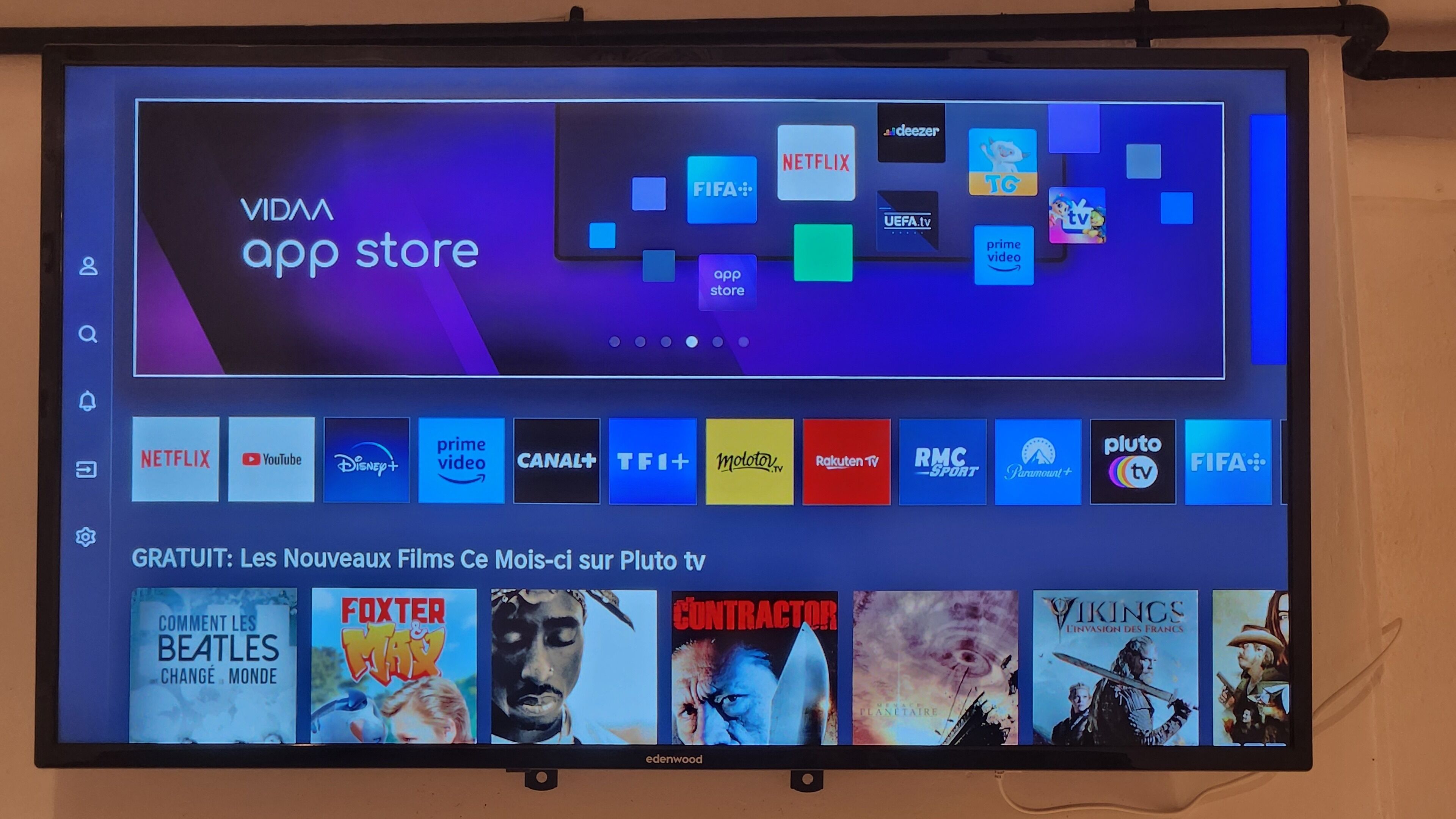 Ein Fernsehbildschirm zeigt eine digitale App-Oberfläche mit verschiedenen App-Symbolen, darunter Netflix und YouTube.
