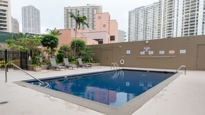 A swimming pool with lounge chairs and a view of tall buildings in the background. - **Diamond Head, Ocean, and Park Views** (Honolulu)