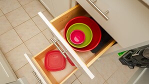 A kitchen drawer with nested bowls and a red plate. - **Diamond Head, Ocean, and Park Views** (Honolulu)