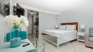 A modern bedroom with a bed, bedside tables, a TV, and a glass table with a vase. - **Diamond Head, Ocean, and Park Views** (Honolulu)