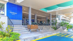 A modern building entrance with a blue sign reading "AQUA ALOHA SURF". - Studio with King size bed & Short walk to Beach (Honolulu)