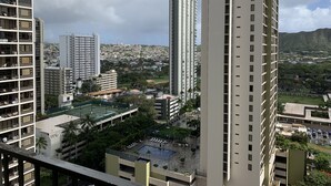 A high-rise building with multiple floors, a rooftop pool, and surrounding greenery. - Beautiful Waikiki Banyan (Honolulu)