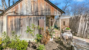 A rustic wooden building with a sign reading "CaptSt Cottage". - Centre St. Cottage | 1/1, King Bed, Mini Kitchen (Fredericksburg)