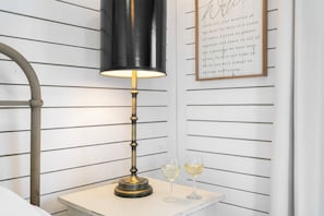 Une table avec une lampe et deux verres de vin blanc.