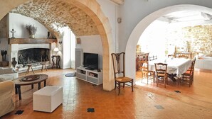 Amplia sala de estar con chimenea, televisor y comedor.