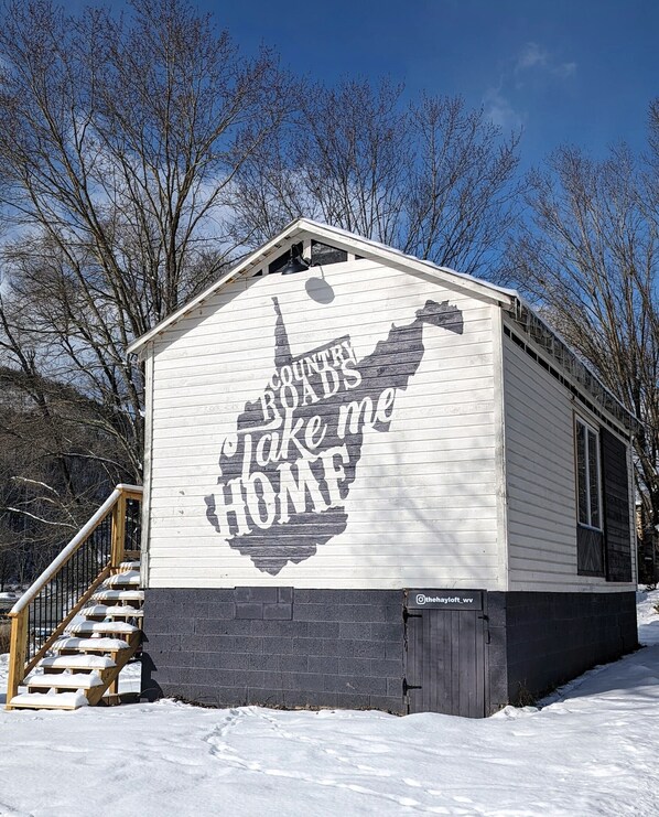 A cabin with a sign reading "Country Roads Take Me Home" on its side. - Charming restored barn with 2 bedrooms, 2 baths in beautiful WV mountains (Mathias)