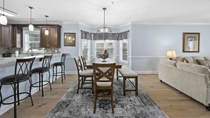 A modern kitchen with dark wood cabinets, a central island, and pendant lighting.