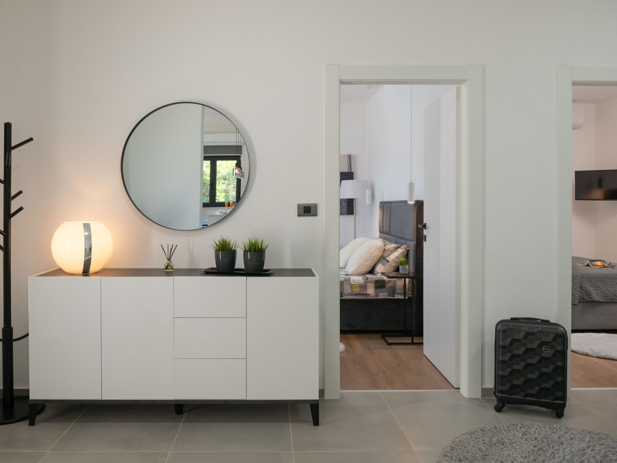 Une chambre à coucher moderne et minimaliste, dotée d’un grand lit, de tables de chevet et d’un dressing.