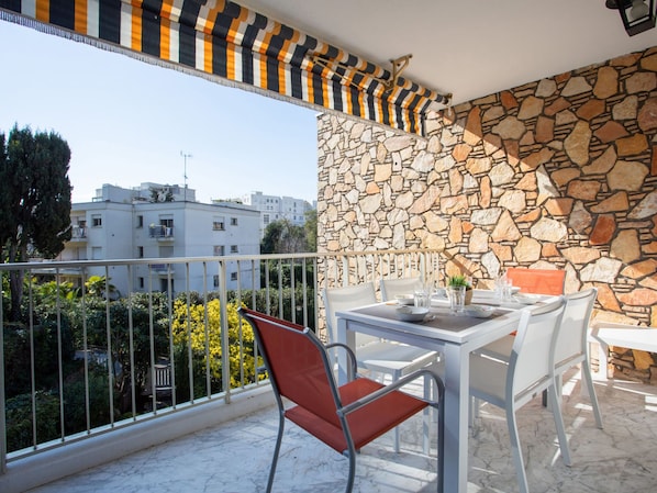 Enjoy the view from this balcony with a table and chairs, perfect for taking in the sights of the surrounding neighborhood.