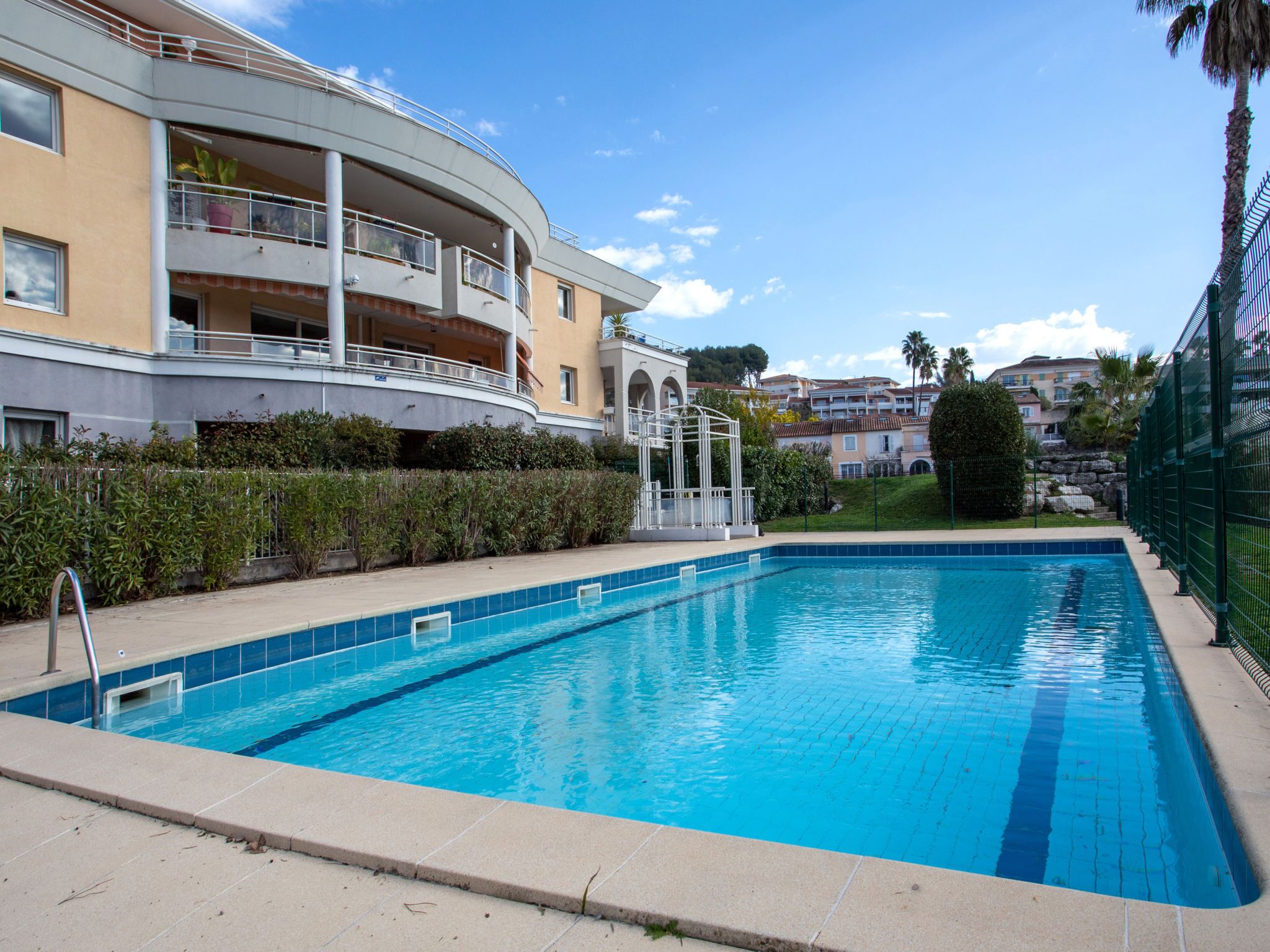 Une piscine à l’eau d’un bleu limpide, entourée d’une terrasse carrelée.