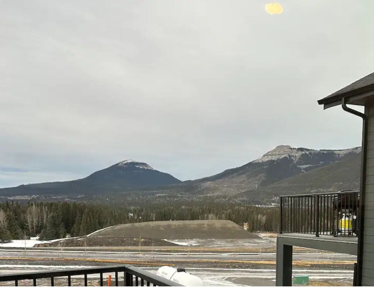 A mountain landscape with a building in the foreground.