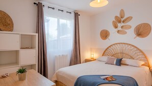 A bedroom with a bed, bedside table, and a wall-mounted shelf.