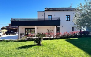 A modern two-story house with a balcony, a garage, and a well-maintained lawn. - Cozy home in Colonnella (Colonnella)