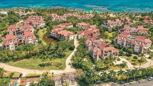 Un complex turístic amb diversos edificis, cadascun amb teulades vermelles, envoltat de vegetació abundant i vistes a l'oceà.