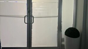 Een kamer met een schuifglasdeur naar een balkon, een bloempot en een betegelde vloer.