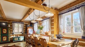 A rustic cabin interior with a wooden dining table, chairs, and a large window. - Charming Mountain Lodge & Wellness by Interhome (Horní Maršov/Pec pod Sněžkou)