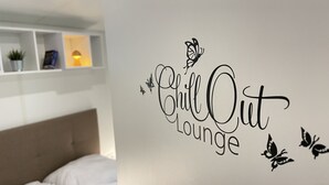 Un mur sur lequel est inscrit le texte « Chill Out Lounge » et où sont peints des papillons décoratifs.