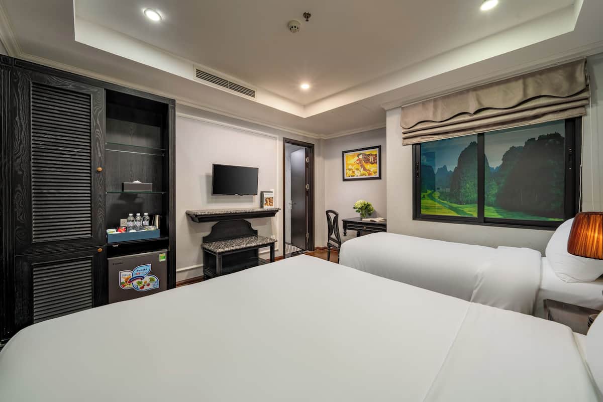 Une chambre d’hôtel avec un grand lit, une télévision, un bureau et un tableau.