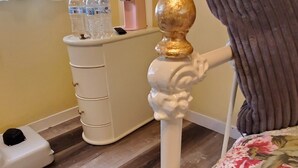 Een slaapkamer met een bed, een dressoir, een waterdispenser en een dierenbed.