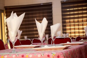 A dining area with tables set for service, featuring white napkins and clear glassware. - Hotel Kinyao (Parakou)