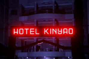 A neon sign reading "HOTEL KINYAO" in a modern building. - Hotel Kinyao (Parakou)