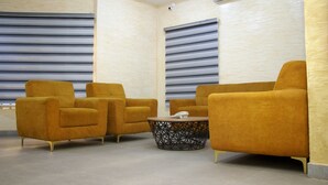 Une pièce avec deux fauteuils de couleur moutarde et une petite table basse ornée d’un motif géométrique.