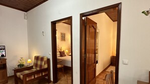 A spacious room with a tiled floor, wooden furniture, and a wooden ceiling. - Quinta Jardim das Palmeiras, T2 nº6, Algoz (Silves)