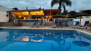 Relax by the pool surrounded by comfortable lounge chairs and umbrellas.