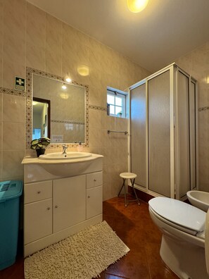 Bathroom features a sink, toilet, shower, and storage cabinet.