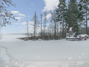 Un paysage enneigé avec une cabane et des arbres.