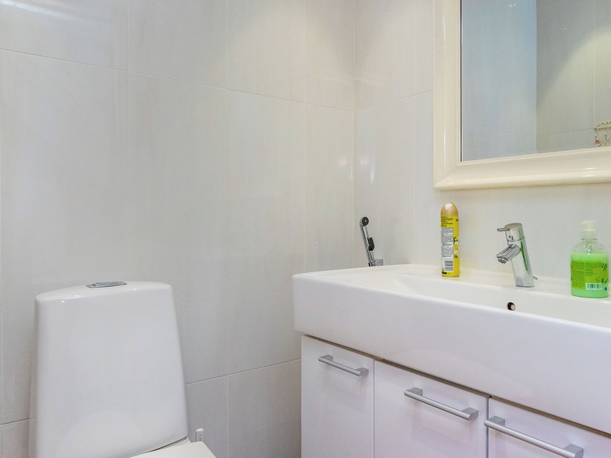 Une salle de bain comprenant des toilettes, un lavabo avec un miroir et des articles de toilette.