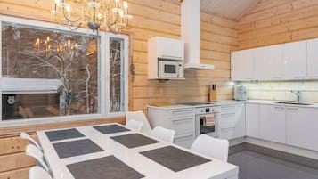 A modern kitchen with white cabinets, a built-in microwave, and a stainless steel sink.