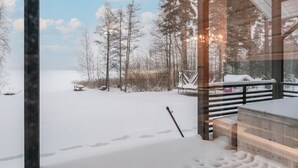 Un paysage enneigé avec une terrasse en bois et un banc.