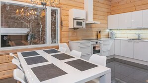 Une cuisine moderne avec des meubles blancs, un four à micro-ondes et un évier en acier inoxydable.