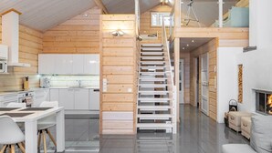 Un intérieur moderne comprenant une cuisine, un coin repas, un escalier et un salon.