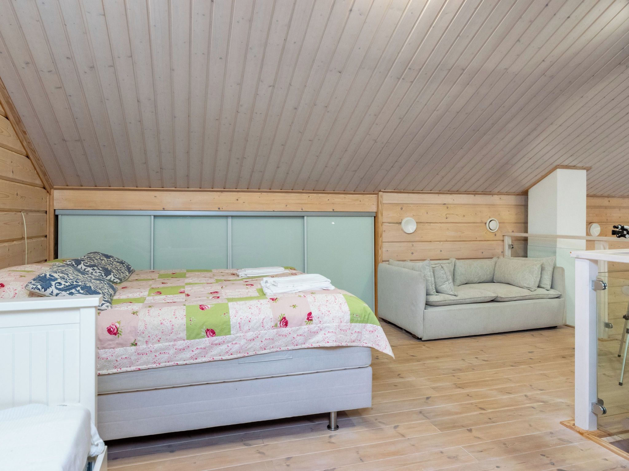 Une chambre à coucher avec un lit, un canapé et un bureau doté d’un miroir.