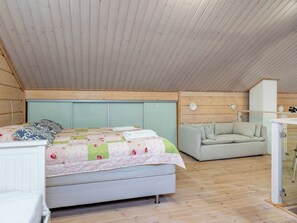 Un dormitorio con una cama, un sofá y un escritorio con un espejo.