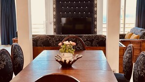 Une table à manger agrémentée d’un centre de table floral, entourée de chaises rembourrées ornées de motifs floraux.