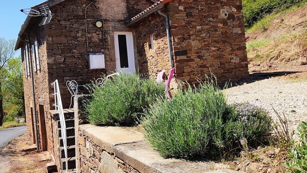 A rustic stone house with a small porch, a wooden staircase, and a thatched roof. - Maisonnette a la Campagne au Calme (Broquiès)