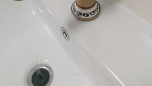 A bathroom sink with a brass faucet and a white porcelain basin.
