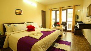 Ein Hotelzimmer mit Bett, Schreibtisch, Stuhl und einem fensterbepflanzten Fenster.