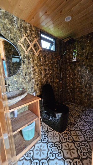 Cozy retreat with a wooden ceiling, stone-like walls, and a comfortable chair.