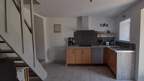 Cocina moderna con lavavajillas integrado, estación de café y vistas a la piscina exterior.