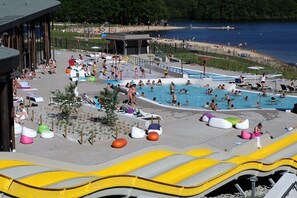 Ett poolområde med flera pooler, solstolar och vattenrutschkanor.