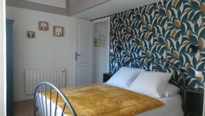 Un dormitorio con cama, radiador, puerta y pared con diseño.