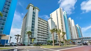 A hotel with multiple high-rise buildings, palm trees, and a clear blue sky.
