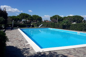 A rectangular swimming pool with a stone deck surrounding it. - Azzurra Suite - studio apartment with WiFi pool and air conditioning (Sirmione)
