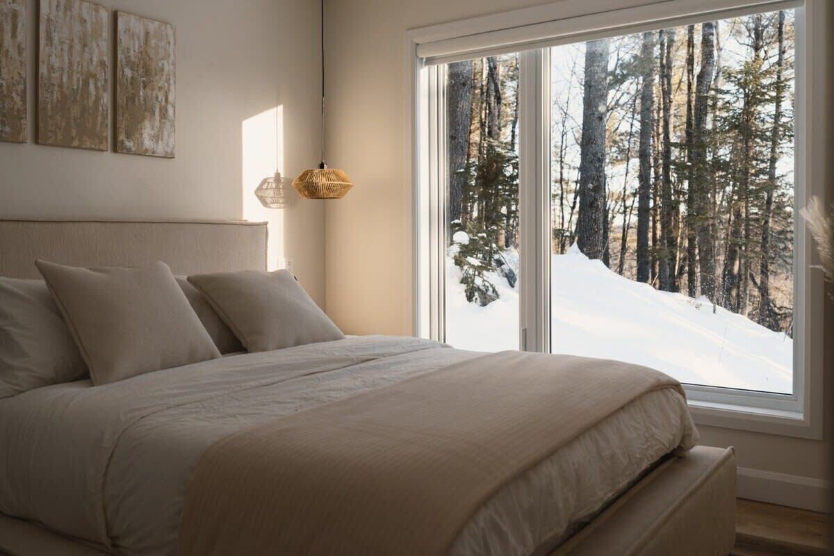 Un lit Queen douillet avec vue sur la nature.
